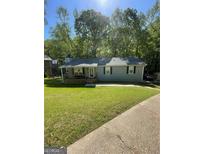 Charming single-story home with gray siding, front porch, and well-maintained lawn at 4070 Feather Dr, Douglasville, GA 30135