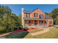 Charming two-story brick home with a inviting front porch and well-manicured landscaping at 2436 Green Hollow Ct, Conyers, GA 30012