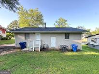 Exterior shot of a white brick home with an enclosed backyard and a well-maintained lawn at 4039 Codel Nw St, Atlanta, GA 30331