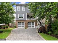 Beautiful two-story home with brick and grey siding, featuring a paver driveway and two-car garage at 1104 Victoria Ne St, Atlanta, GA 30319