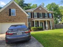 Beautiful two-story brick home with a well-manicured lawn and mature trees providing shade at 692 Sedgwick Dr, Jonesboro, GA 30238