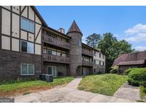 Three-story apartment building with brick and siding exterior, multiple balconies, and unique turret design at 1017 Camelot Dr, Atlanta, GA 30349