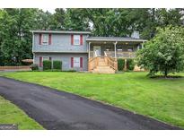 Well-maintained home with a spacious front yard and a welcoming porch with wooden stairs at 123 Mill, Dallas, GA 30157
