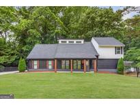Charming home with a manicured lawn, striking dark trim, and stylish wood porch columns at 347 Chip Rd, Stone Mountain, GA 30087