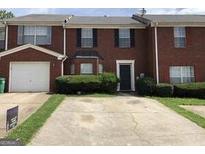 Traditional brick townhome with front yard and attached one car garage at 5658 Wind Gate Ln, Lithonia, GA 30058
