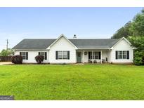 Inviting single story home with lush green lawn and welcoming covered porch at 1195 New Hope Rd, Locust Grove, GA 30248