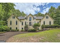 Stately two-story home featuring manicured landscaping and a symmetrical facade with arched windows at 5940 Plantation Dr, Roswell, GA 30075