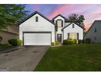 Charming home features a manicured lawn, two-car garage, and classic white siding with black trim details at 1535 Fenmore St, Lithia Springs, GA 30122