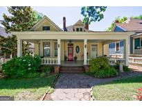 Charming yellow home featuring a spacious front porch with white columns and a red front door at 381 Cherokee Se Ave, Atlanta, GA 30312