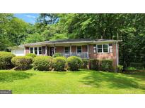 Charming brick home with a well-manicured lawn and mature trees offers great curb appeal at 766 Virginia Cir, Forest Park, GA 30297