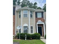 Two-story townhome with brick and vinyl siding, tidy landscaping, and inviting front porch at 8170 Oakley Cir # 2, Union City, GA 30291