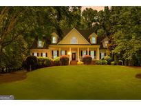 Charming traditional home with a large front lawn, lush landscaping, and welcoming front porch at 220 Broadmoor Dr, Fayetteville, GA 30215