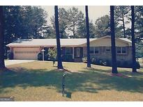 Charming ranch-style home with a brick facade, a two-car garage, and a well-maintained front lawn at 5125 Flakes Mill Rd, Ellenwood, GA 30294
