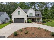 Stunning two-story modern farmhouse with a gray garage, concrete driveway, and lush landscaping at 2490 S Carroll St, Villa Rica, GA 30180
