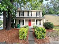 Charming two-story home featuring a bright red front door and well-maintained landscaping at 2146 Wingfoot Pl, Decatur, GA 30035