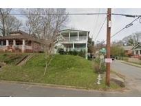 Charming two-story home featuring double balconies and a lush, green lawn on a tree-lined street at 415 Hopkins Sw St, Atlanta, GA 30310