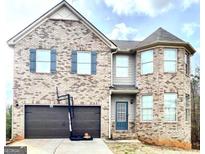Two-story brick home with a basketball hoop, attached garage, and a welcoming blue front door at 413 Atlas Ct, Locust Grove, GA 30248