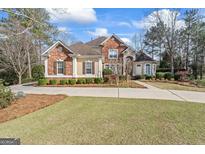 Beautiful brick home with a well-manicured lawn and inviting circular driveway at 612 Champions Dr, Mcdonough, GA 30253