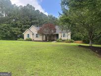 Charming single Gathering home with a well manicured lawn, mature trees, and blue shutters at 803 Pointe Trl, Locust Grove, GA 30248