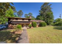 Well-maintained two-story home with mature trees, brick accents and a large front yard in a quiet neighborhood at 6214 Crestview Se Dr, Covington, GA 30014