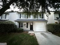 Charming two-story home with a one-car garage, manicured lawn, and freshly painted light gray siding at 408 Kendall Ln, Mcdonough, GA 30253