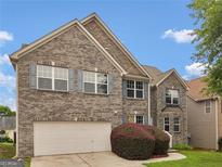 Traditional two-story home featuring a brick facade, attached garage, and landscaped front yard at 3430 Grand Manor Trl, Snellville, GA 30039