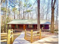 Charming front exterior of a house with a porch, wood accents, and a well-manicured lawn at 3452 Monica Sw Ln, Conyers, GA 30094