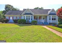 Charming home featuring a well-maintained lawn, lovely shrubs, and attractive curb appeal at 221 Ashley Trace Dr, Locust Grove, GA 30248