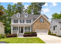 Charming two-story home featuring stone accents, a welcoming front porch and a manicured lawn at 1596 Fearn Ne Cir, Brookhaven, GA 30319