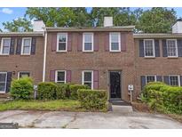 Traditional brick townhome with symmetrical facade, multi-pane windows and manicured greenery at 244 Timber Creek Ln, Marietta, GA 30060