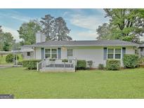 Charming single-story home with a well-manicured lawn and welcoming front porch with flower planters at 270 E James Cir, Hampton, GA 30228