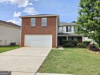 Charming two-story home with a brick front, attached garage, and well-maintained lawn at 1110 Saint Phillips Ct, Locust Grove, GA 30248