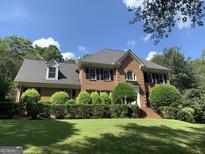 Beautiful two-story brick home with manicured landscaping and a well-maintained lawn at 30 Highlands Ln, Oxford, GA 30054