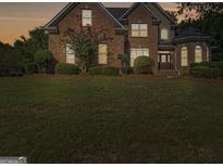 Charming brick home with manicured lawn and mature landscaping at 1500 Royce Dr, Locust Grove, GA 30248