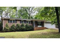 Charming brick home with black shutters, a well-manicured lawn, and mature trees at 5724 Amalfi Way, Douglasville, GA 30135