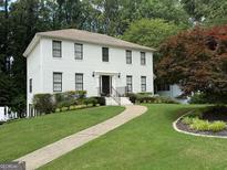 Charming two-story white brick home with beautifully landscaped front yard and inviting walkway at 1560 Boxwood Nw Trce, Acworth, GA 30102