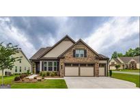 Charming single-Gathering home with stone accents, manicured lawn, and a spacious three-car garage at 209 Cottonwood Cir, Peachtree City, GA 30269