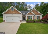 Charming single-Gathering home with a well-manicured lawn, garage, and beautiful wood and stone accents at 9178 Lakeview Pkwy, Villa Rica, GA 30180