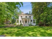 Stately two-story home with classic white columns and a lush green lawn surrounded by mature trees at 818 Springdale Ne Rd, Atlanta, GA 30306