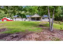Charming single-story home with a well-manicured lawn and a detached red garage at 75 Barber Rd, Carrollton, GA 30116