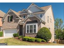 Charming brick two-story home featuring manicured landscaping and attached two car garage at 2321 Norbury Se Cv, Smyrna, GA 30080