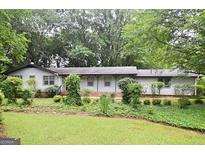 Charming single-story home with a well-maintained front yard and mature trees at 1590 Colonial South Sw Dr, Conyers, GA 30094