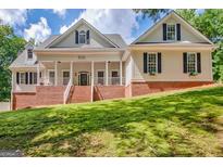 Charming two-story traditional home featuring a welcoming front porch and brick accents at 305 Postwood Dr, Fayetteville, GA 30215