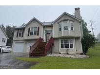 Charming two-story home featuring a well-maintained lawn, attached garage, and classic siding at 650 Flippen Rd, Stockbridge, GA 30281