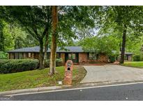 Charming brick home with mature trees and well-maintained landscaping at 1124 Ponderosa Park Dr, Forest Park, GA 30297