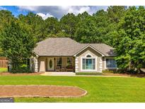 Charming home featuring a well-manicured lawn and a welcoming entrance with seating at 130 Laurel Lake Rd, Tyrone, GA 30290