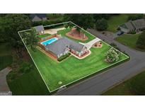 Expansive aerial view of home highlighting the landscaped lawn and refreshing swimming pool at 15 Livingston Way, Covington, GA 30016