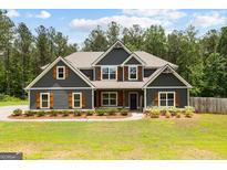Charming two-story home with gray siding, wood accents, and landscaped front yard at 74 Riverwood Trl, Grantville, GA 30220