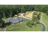 Expansive property featuring a large house, horse arena, and outbuildings surrounded by lush greenery at 135 Brookshire Dr, Fayetteville, GA 30215