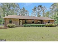 Charming one-story brick home with manicured lawn and lush surrounding greenery at 9706 Holly Hill Way, Jonesboro, GA 30238
